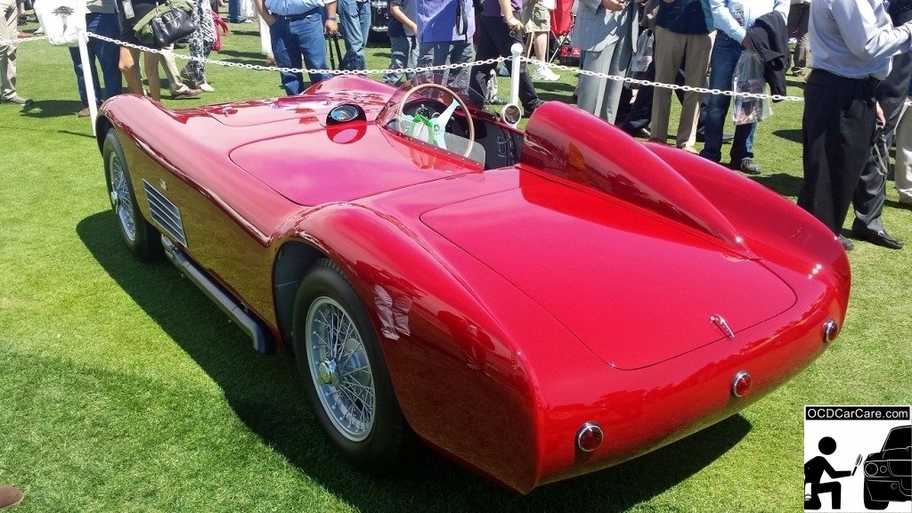 The Color of the 1956 Maserati 150S turned from a deep burgandy to a blindingly vivid red when the sun finally revealed itself on the Sunday lawn. The 1956 Maserati 150S admired by the crowd at the 2014 Pebble Beach Concours d' Elegance. - www.ocdcarcare.com - (949) 427-1191 - info@ocdcarcare.com