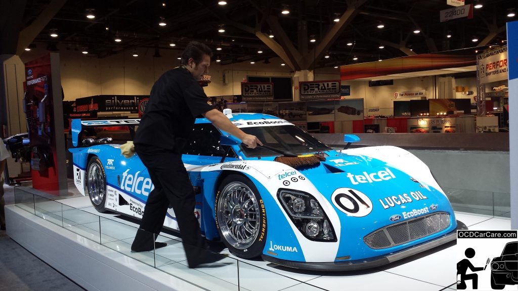 OCDCarCare at SEMA 2013 - Christopher Brown of OCDCarCare dusting down a Ford race car. 